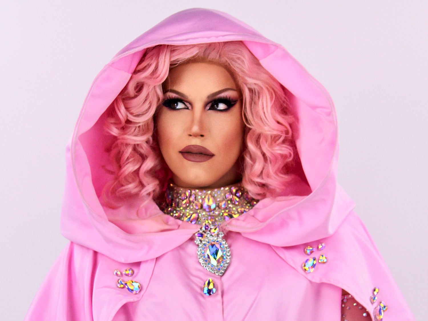 Portrait d'une artiste Drag Queen de l'agence NA Events, magnifiquement maquillée et portant une tenue rose pour une prestation d'animation ou un spectacle.