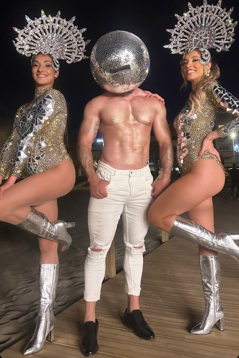 Un danseur et deux danseuse gogo de l'agence NA Events en pleine performance sur la scène d'un club.